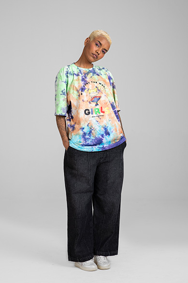 Imagem de uma mulher com camiseta colorida e calça jeans.