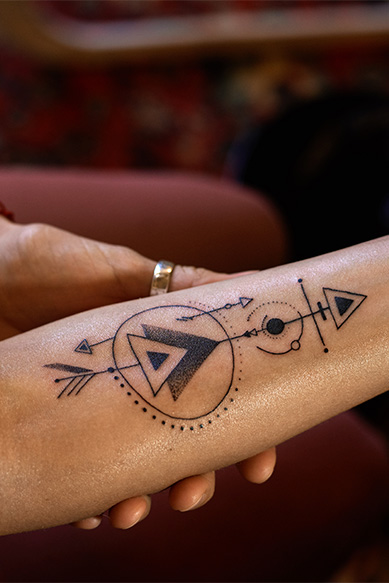 Tatuagem geométrica em braço humano.