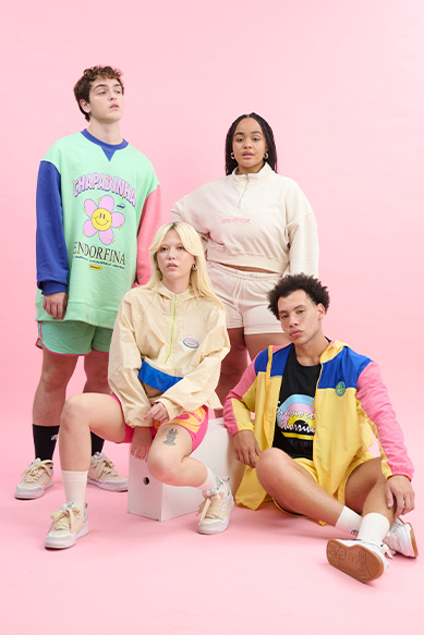 Grupo estiloso de jovens com roupas coloridas em fundo rosa