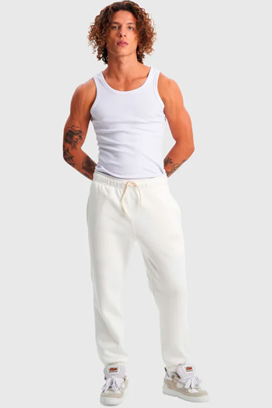 Modelo usando regata e calça branca casual