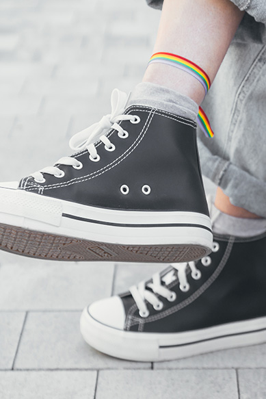 Tênis preto com detalhes brancos e meias coloridas