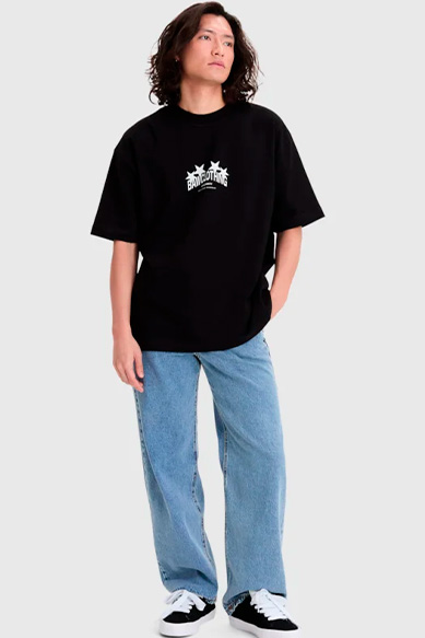 Jovem usando camiseta preta com estampa, calça jeans clara.