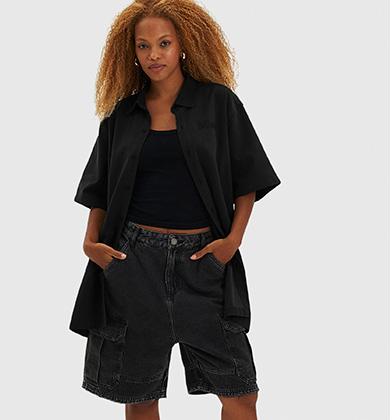 Mulher com camiseta preta e shorts jeans pretos