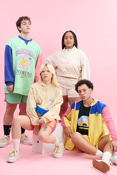 Grupo de jovens com roupas coloridas em fundo rosa