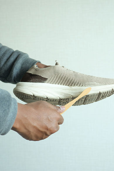 Pessoa limpando um tênis esportivo bege