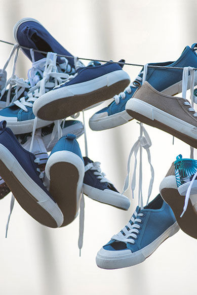 Tênis coloridos pendurados em um varal.