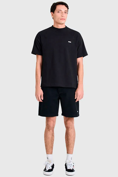 Homem com camiseta preta e shorts escuros