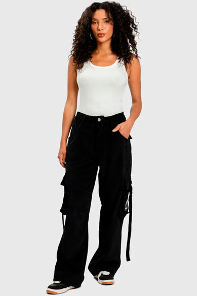 Mulher com calça cargo preta em fundo cinza