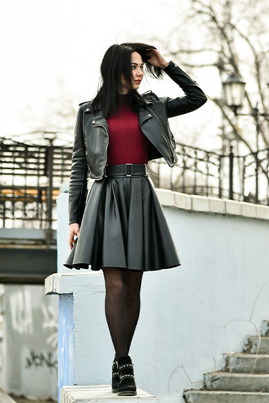 Mulher com vestido de couro e jaqueta de biker