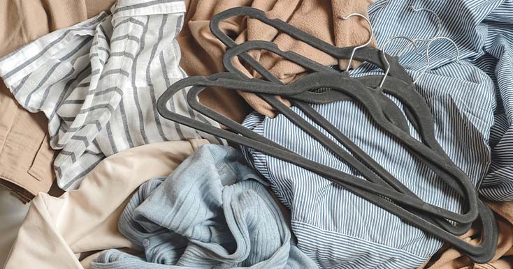Roupas bagunçadas com cabides sobre uma superfície