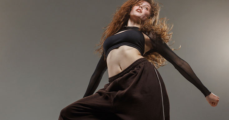 Dançarina com cabelos cacheados em movimento dinâmico