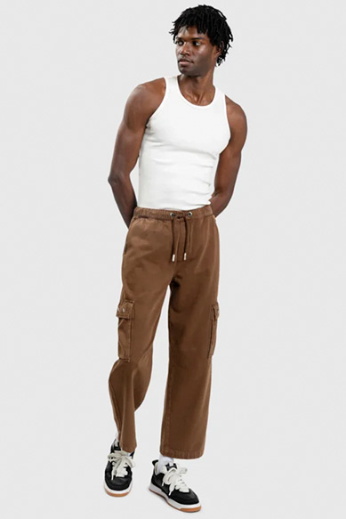 Homem com camisetão branco e calça cargo marrom